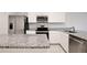 Open-concept kitchen with granite countertops, stainless steel appliances, and white cabinetry at 421 Sedgewick Dr, Davenport, FL 33837