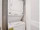An efficient, stacked washer and dryer are shown in a closeted space at 421 Sedgewick Dr, Davenport, FL 33837