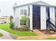 Two-story condo featuring stairs leading up to the second floor and lush green landscaping at 4882 S Semoran Blvd # 1408, Orlando, FL 32822