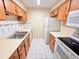Galley kitchen featuring light wood cabinets, white appliances, and tile flooring at 4882 S Semoran Blvd # 1408, Orlando, FL 32822