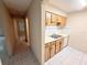 Galley kitchen featuring white appliances, light wood cabinets, and tile flooring at 4882 S Semoran Blvd # 1408, Orlando, FL 32822