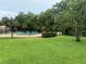 A community pool with lounge chairs surrounded by lush greenery and trees at 4882 S Semoran Blvd # 1408, Orlando, FL 32822