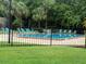 Community pool surrounded by mature landscaping and lounge chairs at 4882 S Semoran Blvd # 1408, Orlando, FL 32822