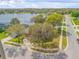 Lakefront home featuring mature trees, a well-maintained lawn, and a charming exterior at 524 Quail View Ct, Debary, FL 32713