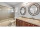 Bathroom featuring double sinks, decorative mirrors, and a shower-tub combo for ultimate relaxation at 524 Quail View Ct, Debary, FL 32713