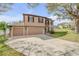 Beautiful two-story home with a three-car garage, complemented by a well-kept lawn and mature trees at 524 Quail View Ct, Debary, FL 32713