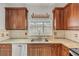 Kitchen sink with stainless steel dishwasher, granite countertop and wooden cabinets at 524 Quail View Ct, Debary, FL 32713