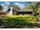 Backyard view of home featuring a sunroom, chimney, green grass, and large trees at 5443 Aeolus Way, Orlando, FL 32808
