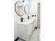 Bright bathroom featuring a double sink vanity with modern black fixtures, sleek round mirrors, and stylish white tile at 5443 Aeolus Way, Orlando, FL 32808