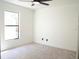 Bright bedroom with neutral carpet, large window, and clean white walls at 5443 Aeolus Way, Orlando, FL 32808