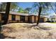 Inviting single-story home featuring a brick facade, large windows, and a mature tree-lined yard at 5443 Aeolus Way, Orlando, FL 32808