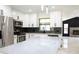 Modern kitchen with stainless steel appliances, black backsplash, an island, and polished marble floors at 5443 Aeolus Way, Orlando, FL 32808