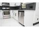 Kitchen featuring modern white cabinetry, stainless steel appliances, gray subway tile backsplash, and white tile floors at 5443 Aeolus Way, Orlando, FL 32808