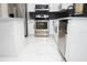 Kitchen featuring modern white cabinetry, stainless steel appliances, gray subway tile backsplash, and white tile floors at 5443 Aeolus Way, Orlando, FL 32808