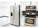 Kitchen with stainless steel appliances, white cabinets, grey subway tile backsplash and eat-in counter at 5443 Aeolus Way, Orlando, FL 32808