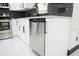 Kitchen featuring modern white cabinetry, stainless steel dishwasher and appliances, gray subway tile backsplash, and white tile floors at 5443 Aeolus Way, Orlando, FL 32808