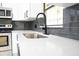 Modern kitchen features stainless steel appliances, white cabinets, grey subway tile backsplash and black hardware at 5443 Aeolus Way, Orlando, FL 32808