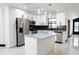 Modern kitchen featuring stainless steel appliances, an island, and polished marble floors at 5443 Aeolus Way, Orlando, FL 32808