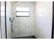 Modern shower with marble-patterned tile, a glass enclosure, black hardware, and a window at 5443 Aeolus Way, Orlando, FL 32808