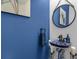 Chic half-bath with pedestal sink, decorative mirror, and stylish blue walls at 599 Glendevon Dr, New Smyrna Beach, FL 32168