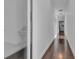 Long hallway with hardwood floors and bright lighting leading to various rooms, enhancing the sense of space at 599 Glendevon Dr, New Smyrna Beach, FL 32168
