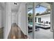 Bright hallway with hardwood floors leading to a pool view, enhancing the home's appeal and connectivity at 599 Glendevon Dr, New Smyrna Beach, FL 32168