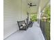 Inviting covered porch with ceiling fan and comfortable seating, perfect for relaxing outdoors at 599 Glendevon Dr, New Smyrna Beach, FL 32168
