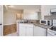 A kitchen featuring a breakfast bar, white cabinetry and a white appliance package at 6340 Raleigh St # 1002, Orlando, FL 32835