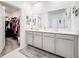 Bathroom vanity with double sinks, neutral decor, and a walk-in closet at 6404 Pine Fork Aly, St Cloud, FL 34771