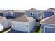 Rear view of gray and white home with a two-car garage and fenced-in backyard at 6404 Pine Fork Aly, St Cloud, FL 34771