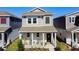 Charming two-story home features a welcoming front porch with a well-manicured lawn and beautiful landscaping at 6404 Pine Fork Aly, St Cloud, FL 34771