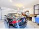 Spacious garage featuring a sleek black car, storage shelves, and ample room for organization at 6404 Pine Fork Aly, St Cloud, FL 34771