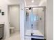 Modern stand-up shower featuring sliding glass doors and gray tiling at 6404 Pine Fork Aly, St Cloud, FL 34771