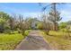 The home's walkway leads up to the house and features a grassy yard and trimmed trees at 7025 Big Bend Dr, St Cloud, FL 34771