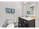 Bathroom with a black vanity, commode and wall-mounted mirror and towel rack at 703 Linden Dr, Winter Springs, FL 32708