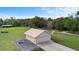 This aerial view highlights the garage, surrounding trees, a long concrete driveway, and surrounding countryside at 735 Deerfoot Rd, Deland, FL 32720