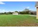 Spacious backyard featuring green grass, mature trees, a shed, and a detached garage at 735 Deerfoot Rd, Deland, FL 32720