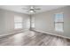 Bedroom with wood-look floors, light colored walls, and bright windows at 735 Deerfoot Rd, Deland, FL 32720