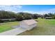 Detached garage with white door and painted exterior on a large manicured lawn and long drive at 735 Deerfoot Rd, Deland, FL 32720