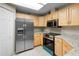 Bright kitchen featuring stainless steel appliances and light wood cabinetry at 735 Deerfoot Rd, Deland, FL 32720