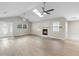 Bright living room with a skylight, fireplace, ceiling fans, and neutral walls and flooring at 735 Deerfoot Rd, Deland, FL 32720