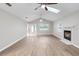 A vaulted ceiling living room showcasing wood floors, a fireplace, skylight, and a decorative front door at 735 Deerfoot Rd, Deland, FL 32720