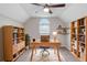 This well-lit office space features bookshelves, a ceiling fan, a decorative rug, and a large window at 735 Deerfoot Rd, Deland, FL 32720