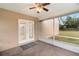 The covered patio features a ceiling fan, screens, outdoor access, and a view of the spacious backyard at 735 Deerfoot Rd, Deland, FL 32720
