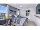 This bedroom features neutral decor, a ceiling fan, a gray accent wall, and a view of the home's exterior at 7351 Capstone Dr, Groveland, FL 34736