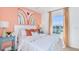 Inviting bedroom featuring a bright rainbow accent wall, cozy bedding, and charming bedside decor, great for a  at 7351 Capstone Dr, Groveland, FL 34736
