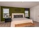 Tastefully decorated bedroom featuring contemporary furnishings, neutral carpet, and an art accent wall at 7355 Capstone Dr, Groveland, FL 34736