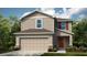 Charming two-story home with neutral siding, a two-car garage, and well-maintained landscaping at 7355 Capstone Dr, Groveland, FL 34736