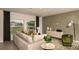 Bright living room featuring large windows, a comfortable sofa, and tasteful decor at 7355 Capstone Dr, Groveland, FL 34736