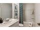 Well-lit bathroom featuring a sink, toilet, bathtub with shower and decorative green and white-themed artwork at 7384 Capstone Dr, Groveland, FL 34736